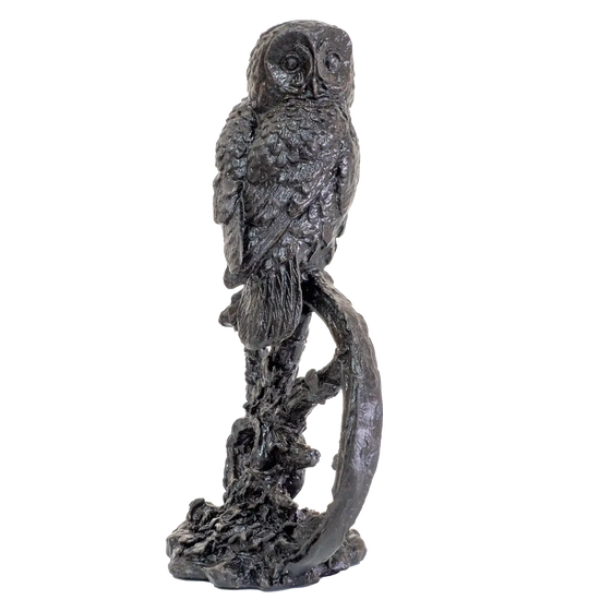 Statue of an owl perched on a branch against a white background