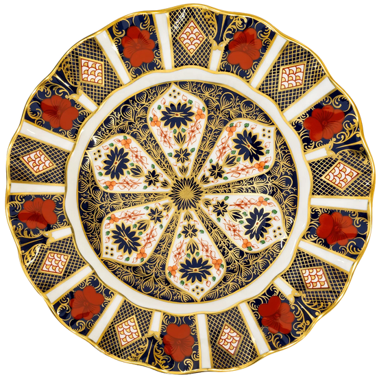 An ornate round ceramic plate with a scalloped rim, featuring a detailed floral and geometric pattern in navy blue, gold, white, and terracotta red.