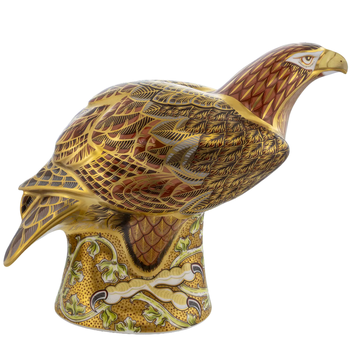 A decorative ceramic eagle figurine perched on a patterned pedestal, featuring intricate gold, brown, and cream detailing against a plain white background.