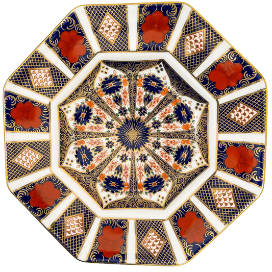An ornate octagonal ceramic plate featuring a complex floral and geometric pattern in navy blue, terracotta red, gold, and white.